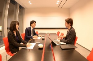 ビビットな印象のミーティングルームで松倉氏からお話を伺っている写真