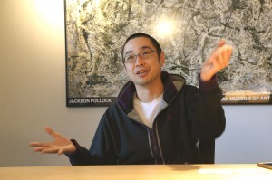 当時のネット環境について、身振り手振りを交えて説明する石橋氏の写真