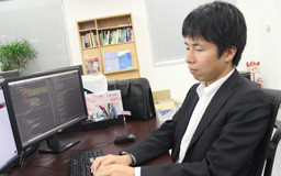 パソコンの前で作業する安藤氏の写真